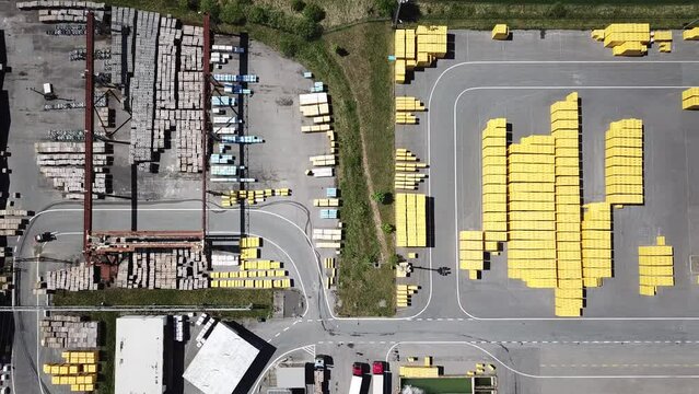 Aerial view of factory plant producing autoclaved aerated concrete. Many packages of building material in blocks. Top down view of industrial area.