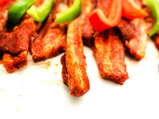 Sliced peppers and marinated spicy pork chops on white background. Asian style food. Uncooked meat for barbeque. High quality fine product