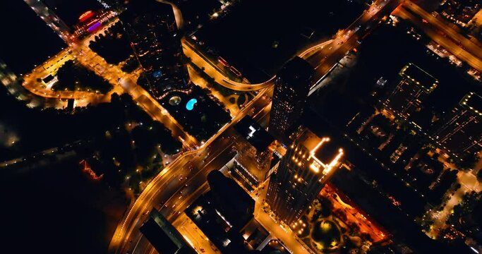 Streets of Chicago are lit with orange light. Cars move quickly by the roads in the evening. Aerial view.