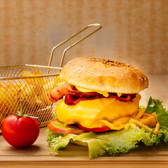 Tasty hamburger with french fries and vegetables
