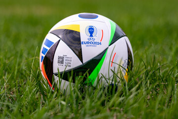 Obraz premium April 17, 2024, Berlin, Germany. The official ball of the European Football Championship 2024 Adidas EURO24 Fussballliebe on the green lawn of the stadium.