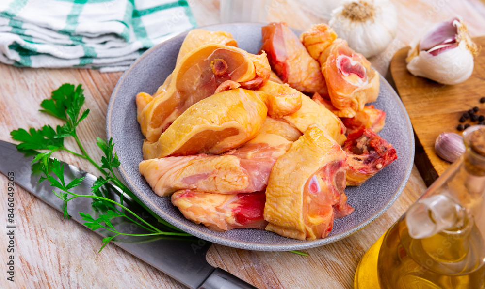 Wall mural chopped uncooked chicken and condiments on kitchen table. preparing food at home.