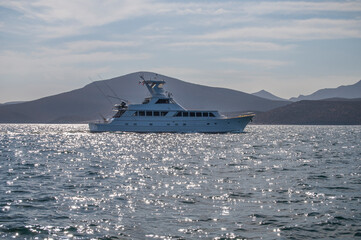 A yacht sailing through the Mexican seas of the Sea of ​​Cortes, off the coast of La Paz, along BALANDRA beach, on a summer vacation morning. MEXICO