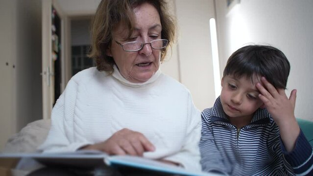 Grandmother reading a book to her attentive grandson in a cozy room, fostering a loving family bond. boy listens intently, highlighting the importance of storytelling and shared moments