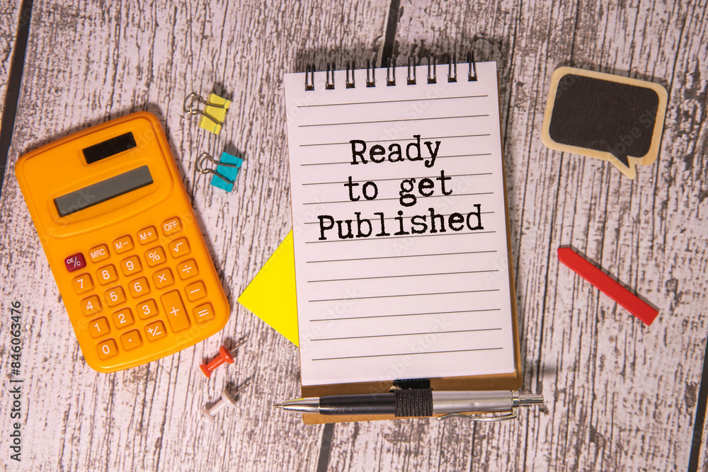 Poster text ready to get published in notebook on white table with office tools