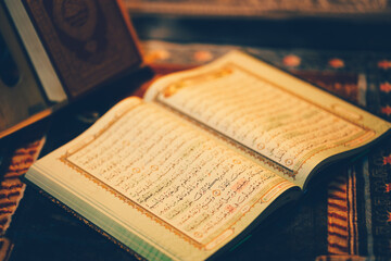 The Quran was opened for reading and had a dim golden glow. Selective focus. The concept of Islam.