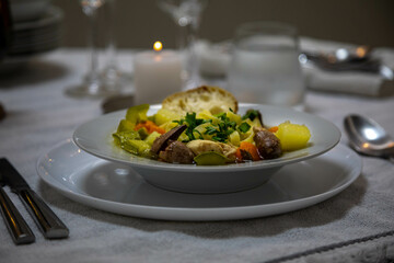 Luxurious table setting with white plates, crystal glasses and fine cutlery. Soup
