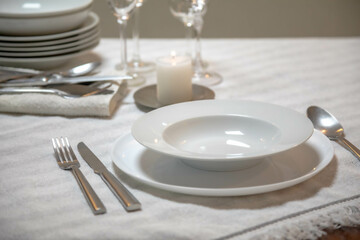 Luxurious table setting with white plates, crystal glasses and fine cutlery