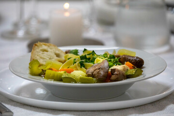 Luxurious table setting with white plates, crystal glasses and fine cutlery. Soup