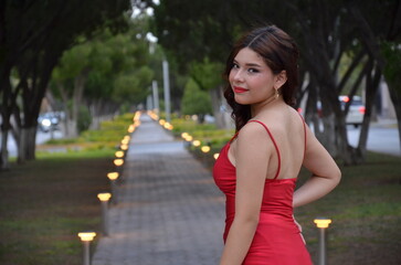 portrait of latina girl in red dress relaxing smile