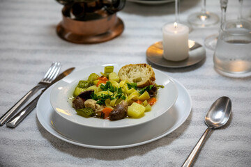 Luxurious table setting with white plates, crystal glasses and fine cutlery