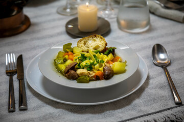 Luxurious table setting with white plates, crystal glasses and fine cutlery