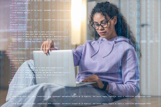 Female African-American programmer working with laptop in office