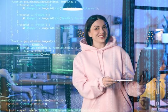 Beautiful programmer with laptop in office at night