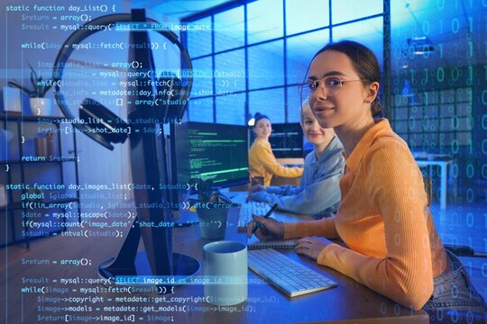 Female programmer with her colleague working in office at night