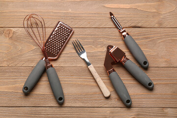 Different kitchen utensils on wooden background