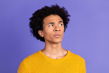 Photo of minded funny man wear trendy yellow clothes look empty space isolated on purple color background