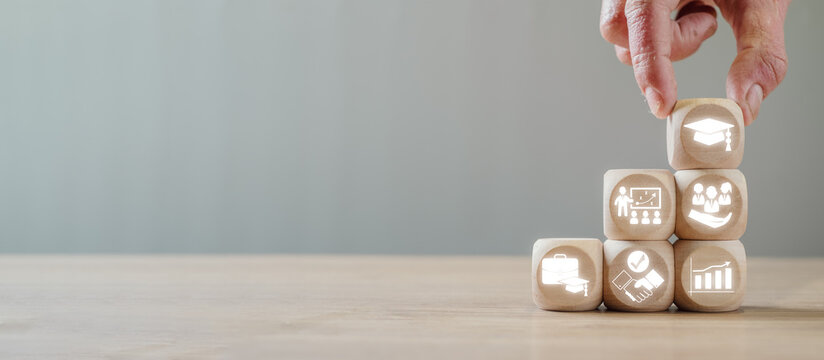 Wooden blocks with icons symbolizing education, training, and career growth, perfect for illustrating professional development and trainee concepts.