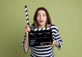 Making movie. Woman with clapperboard on green background