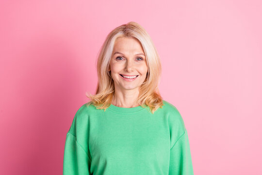 Photo portrait of attractive retired woman look camera dressed stylish green clothes isolated on pink color background
