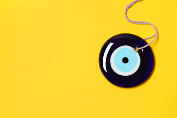 Evil eye amulet on orange background, top view. Space for text