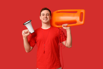 Male lifeguard with rescue tube buoy and megaphone on red background