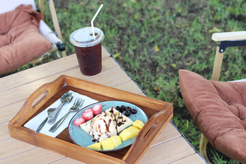 Waffles with ice cream with drinks placed on the picnic table