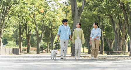 Obraz premium 犬・ペットと遊ぶ家族・ファミリー（両親と子供・3人） 
