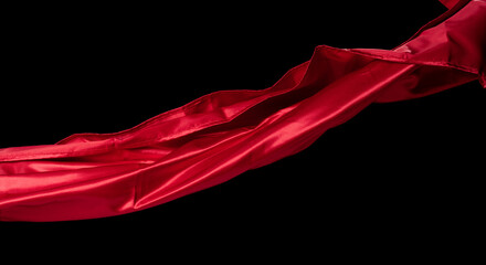 Red Satin fabric flying in curve shape, Piece of textile Red Satin fabric throw fall in air. Black background isolated motion blur