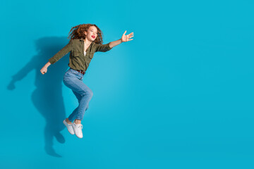 Obraz premium Full body portrait of pretty young woman jump run catch empty space wear shirt isolated on turquoise color background