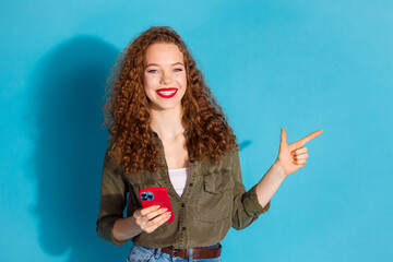 Obraz premium Portrait of pretty young woman phone direct finger empty space wear khaki shirt isolated on turquoise color background