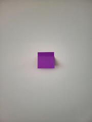 Purple sticker on a white wall. Note sticker on a white background.