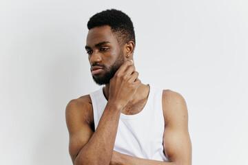 Contemplative african american man in white tank top pondering deep thoughts with hand on chin