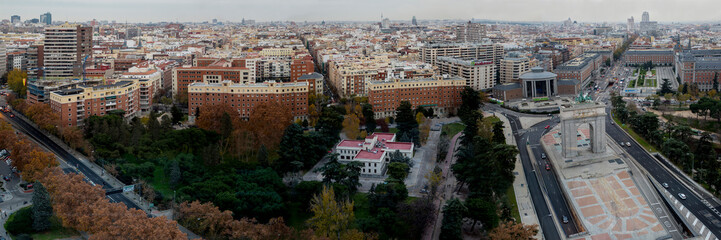Obraz premium A cityscape with a large building in the middle. The sky is cloudy and the buildings are brown
