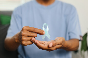 Prostate Cancer Awareness. Man Hand Presenting Light Blue Ribbon