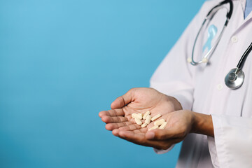 Doctor Hand Holding Pills On Palms Isolated On Blue Background. Prostate Cancer Awareness