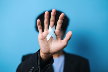 Prostate Cancer Awareness. Man Wearing Black Coat Hannd Holding Light Blue Ribbon For Supporting...