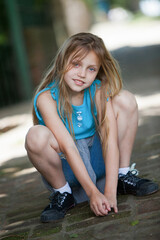 cheerful cute little girl in squatting position.outdoors 