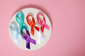 Circle With Colorful Ribbons Of Disease Prevention Campaigns Over Pink Background. World Cancer Day