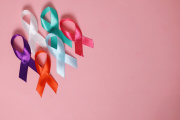 Different Colors Of Ribbon Over Pink Background, International Symbol. Cancer Disease.