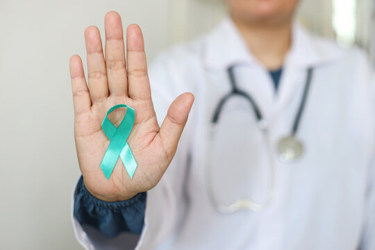 Doctor In White Coat With Teal And White Ribbon Awareness To Support Cervical Cancer. 
