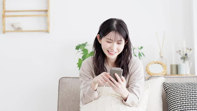 スマホを操作しながら指差しをする女性