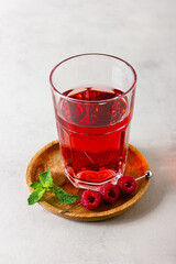 Raspberry drink in the glass on the light background.