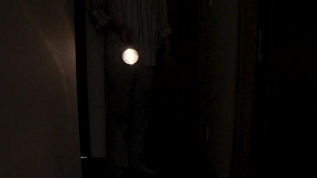暗い廊下を懐中電灯で照らす