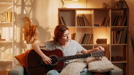 Guitar tuning. Music practice. Woman guitarist adjusting pegs and gears on string acoustic...