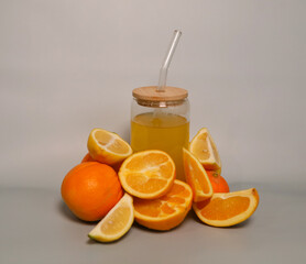 Orange and slices of orange on the background of a glass of orange juice