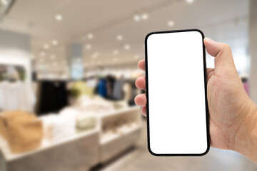 Hand holding blank screen smartphone for copy space on blurred clothing store. e-commerce app shopping mockup. social media, payment and shopping online concept. fashion and technology.