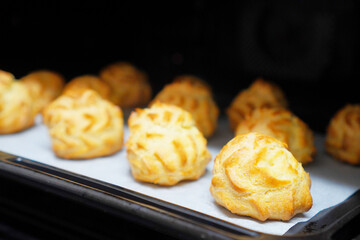 シュークリームを作りたくてシューを焼いたよ。焼きやてのシューをオーブンから取り出すところ。