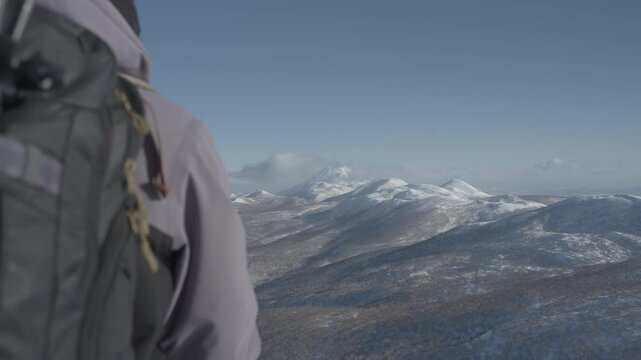 Snowboarder at Hokkaido's Iwanai resort with splitboard overlooking snow-covered mountains