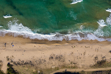 Aerial view of a remote sandy beach and sea waves